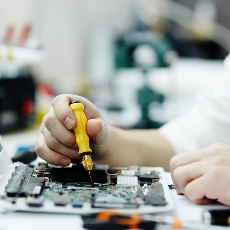 Man Assembling Circuit Board in Laptop